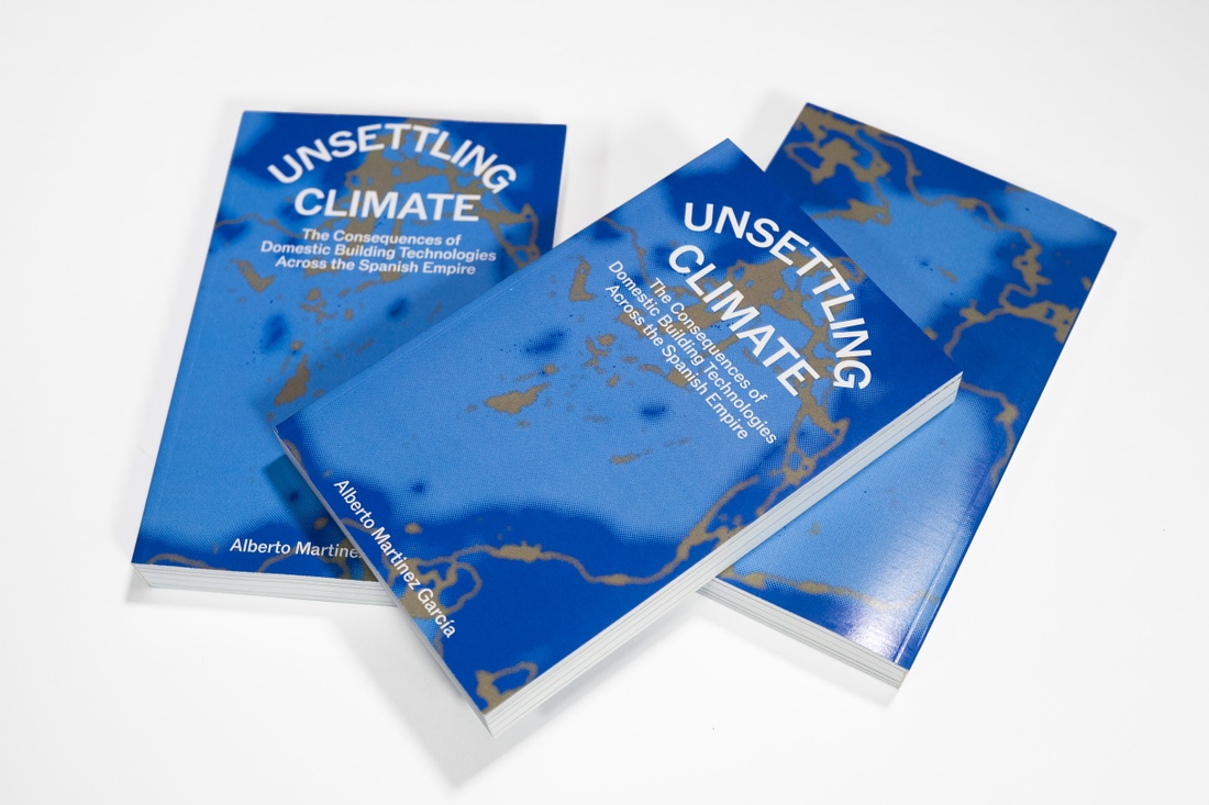 A stack of three blue books with the title of the thesis "Unsettling Climate" its cover.