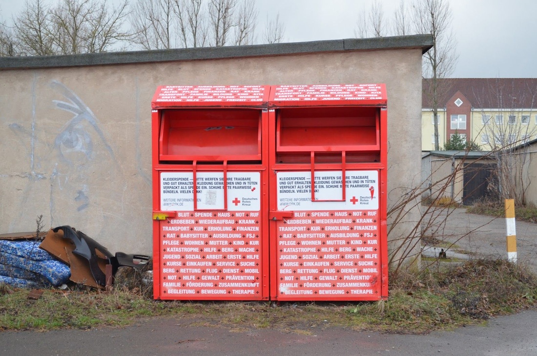 Deutsches Rotes Kreuz donation bin near the Aufnahmeeinrichtung, Eisenhüttenstadt. The facility is visible in the background. Image taken January 2019 by the author.